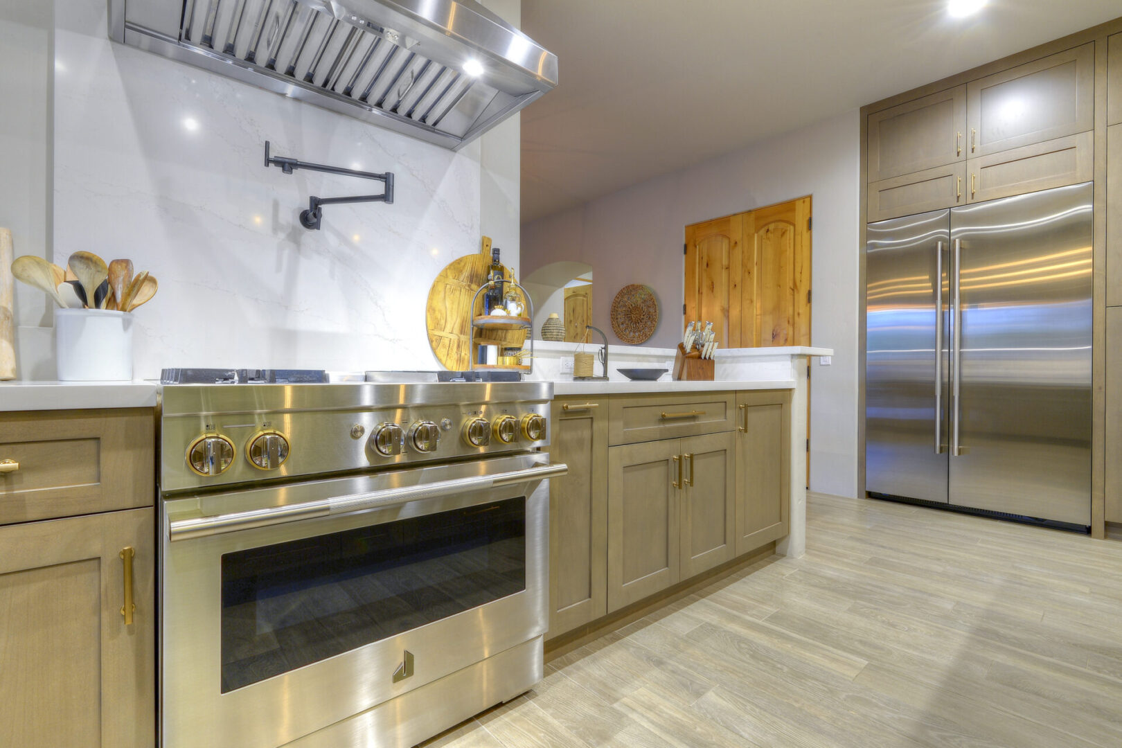 A kitchen with stainless steel appliances and wooden cabinets.