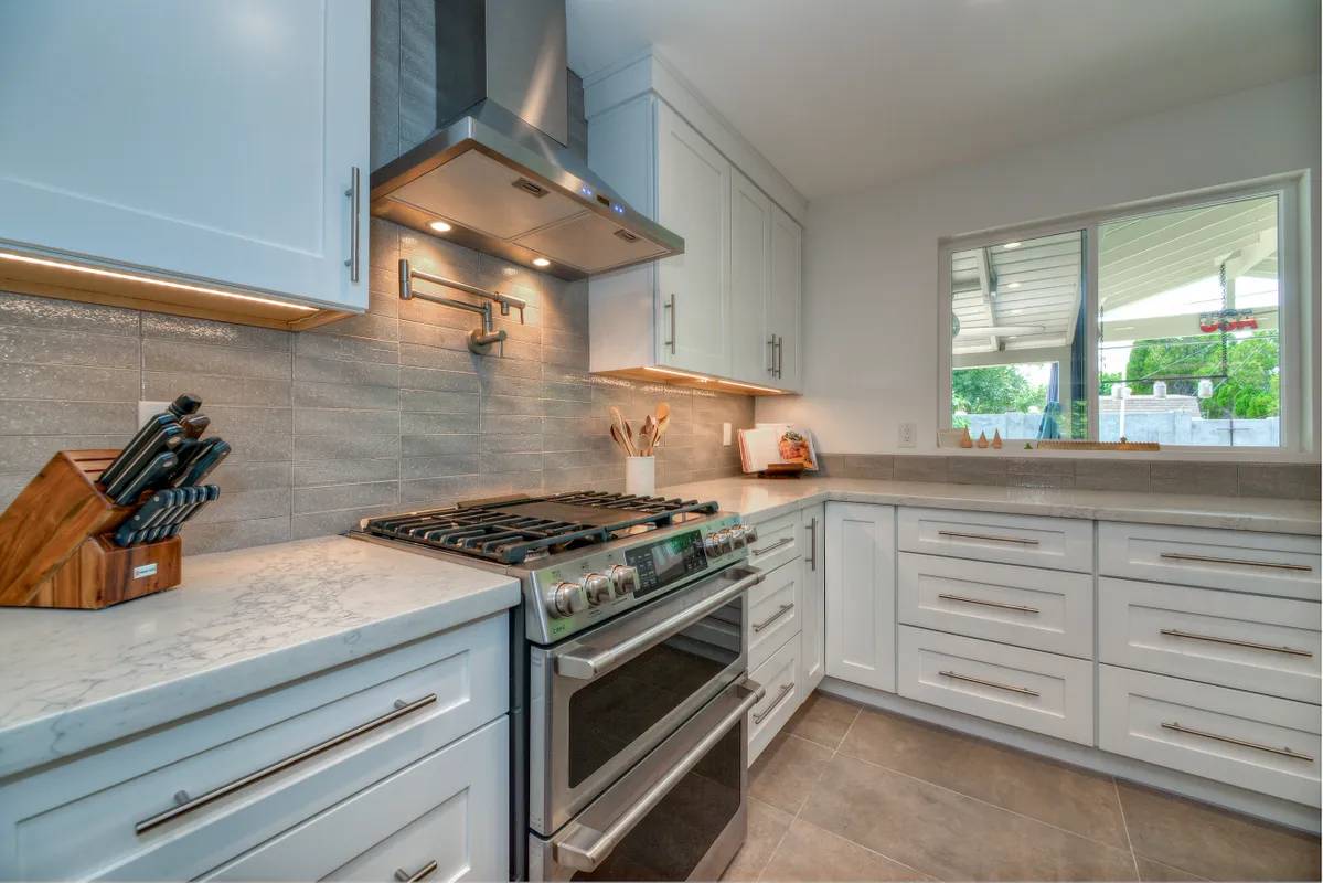 A kitchen with white cabinets and stainless steel appliances.