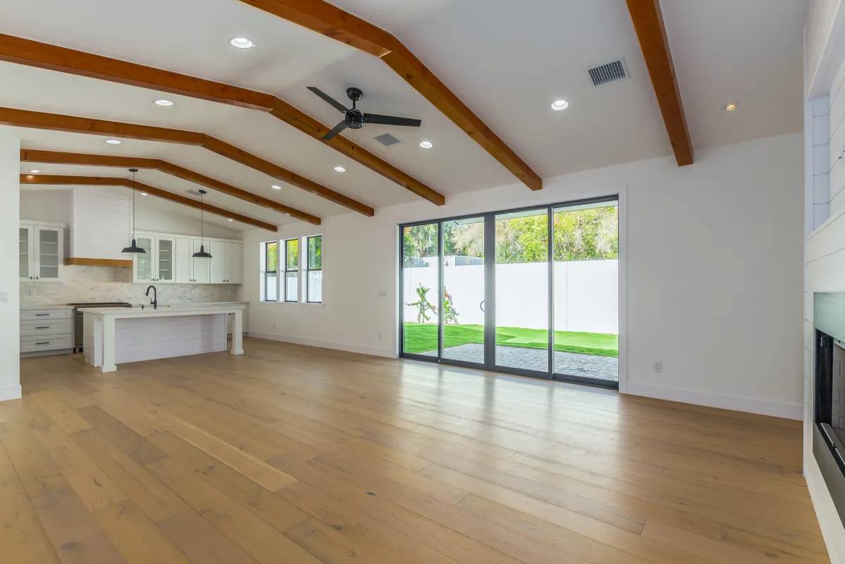 A large open room with wood floors and white walls.