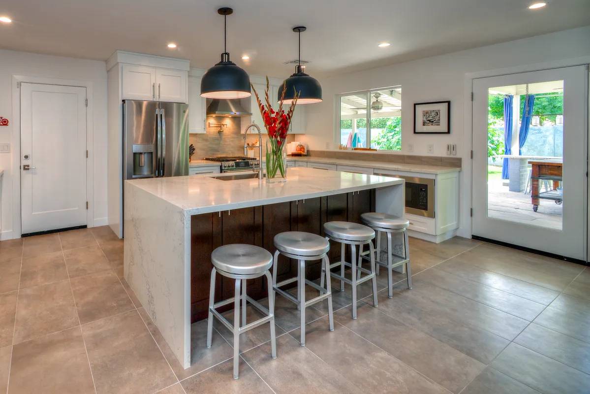 A kitchen with a large island and five stools.