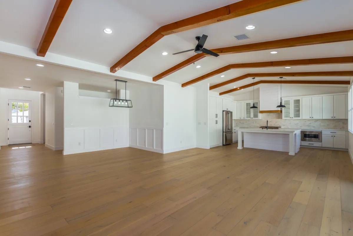 A large open room with wooden floors and ceiling beams.