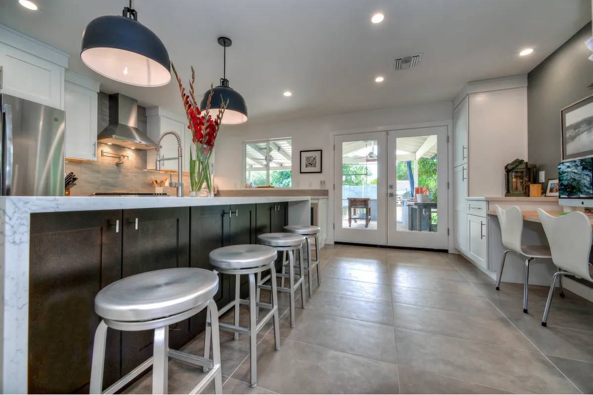 A kitchen with a large island and several stools.