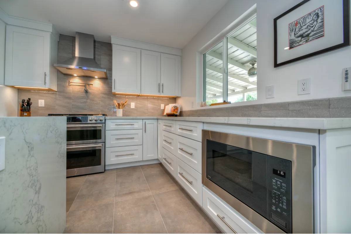 A kitchen with white cabinets and stainless steel appliances.