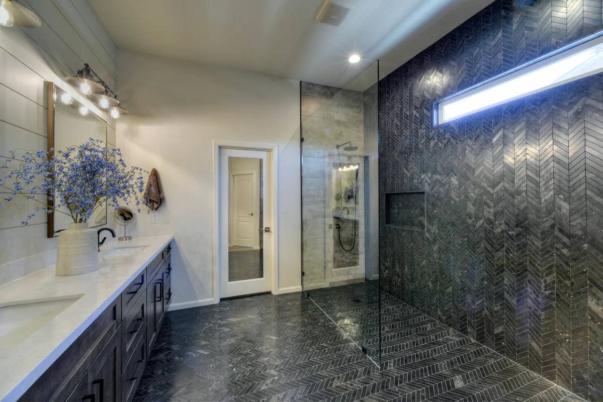 A bathroom with a large walk in shower and double sinks.