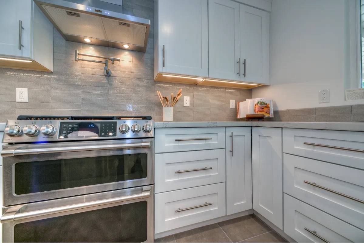 A kitchen with white cabinets and stainless steel appliances.