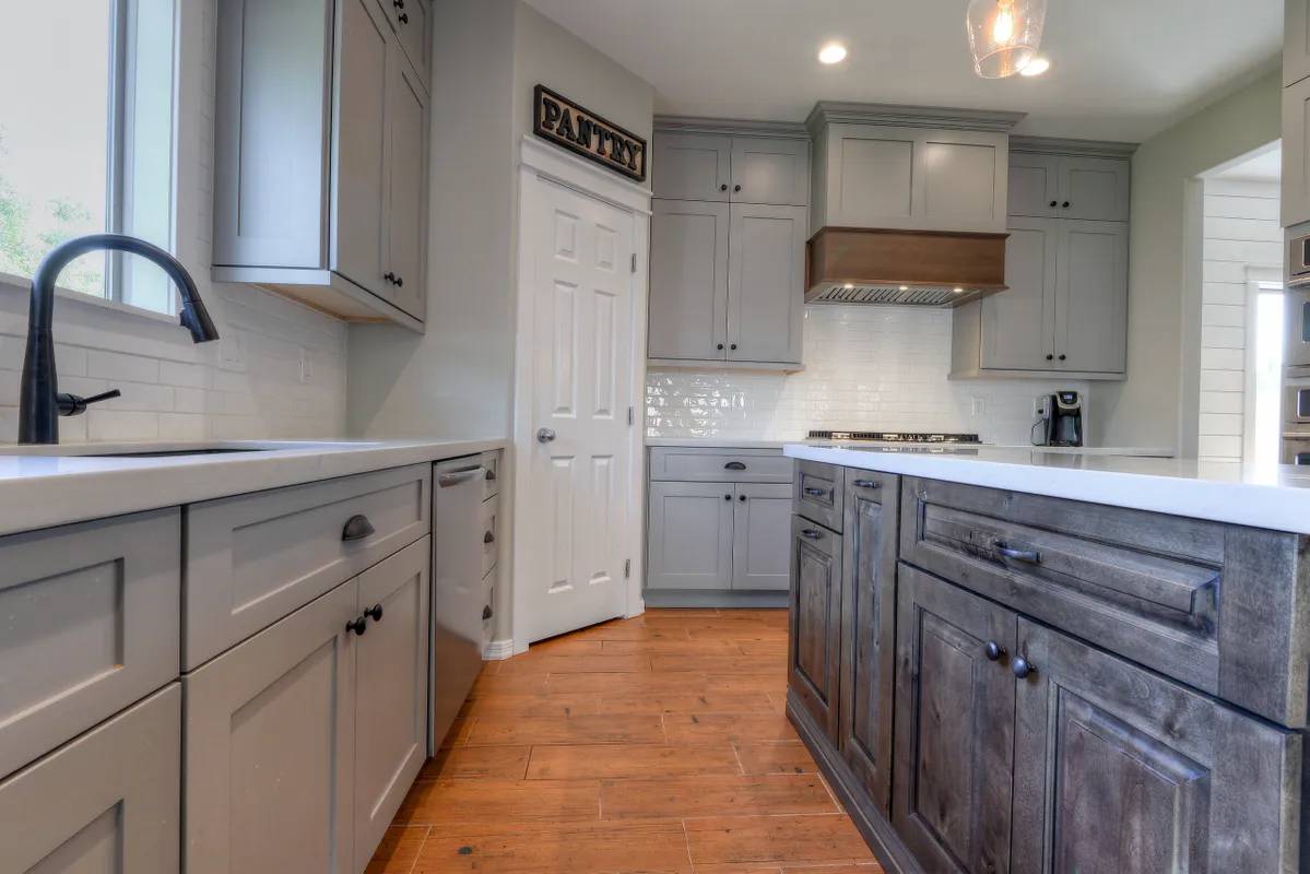 A kitchen with wooden cabinets and white counters.