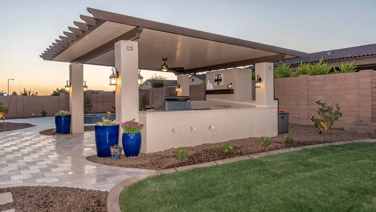 A covered patio with an outdoor kitchen and pool.
