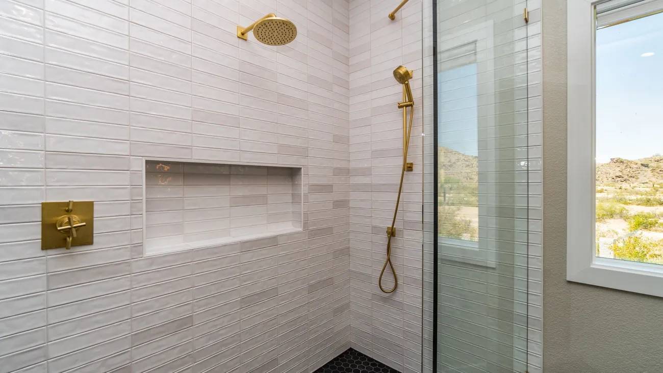 A bathroom with a shower and tiled walls.