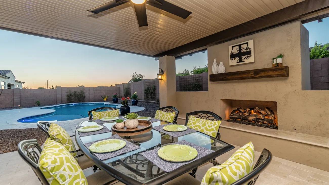 A table with plates and napkins on it in the middle of an outdoor patio.