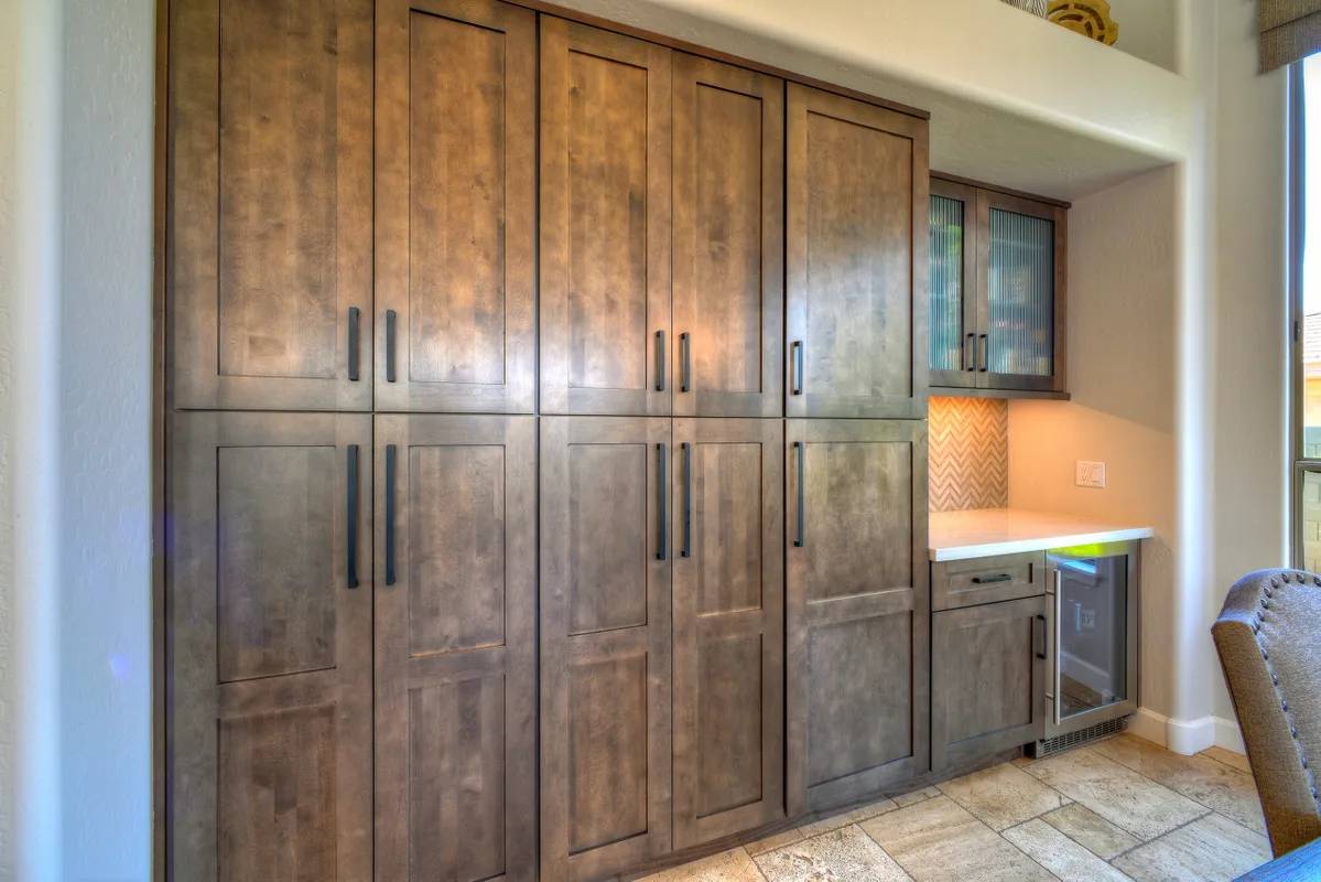 A kitchen with wooden cabinets and tiled floor