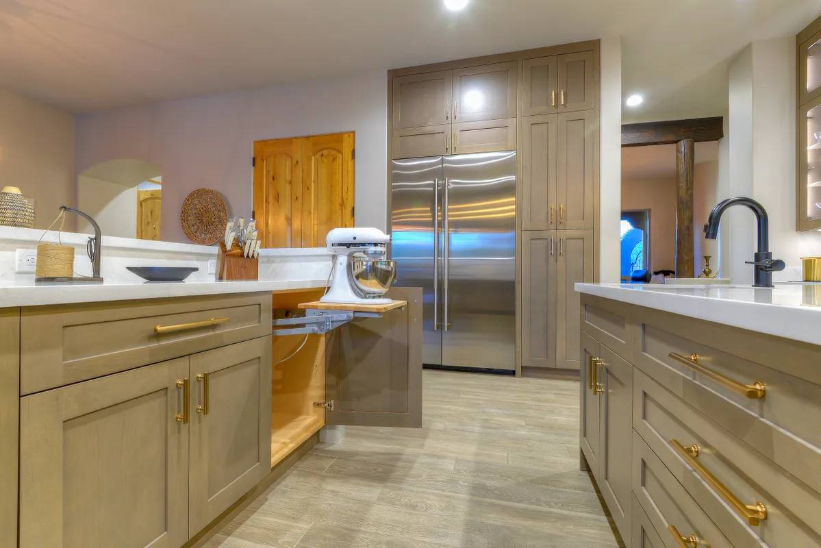 A kitchen with wooden cabinets and floors, and stainless steel appliances.