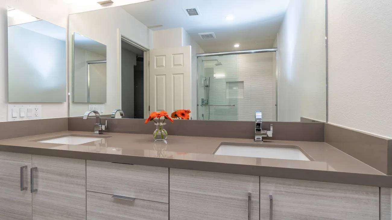 A bathroom with two sinks and a large mirror.