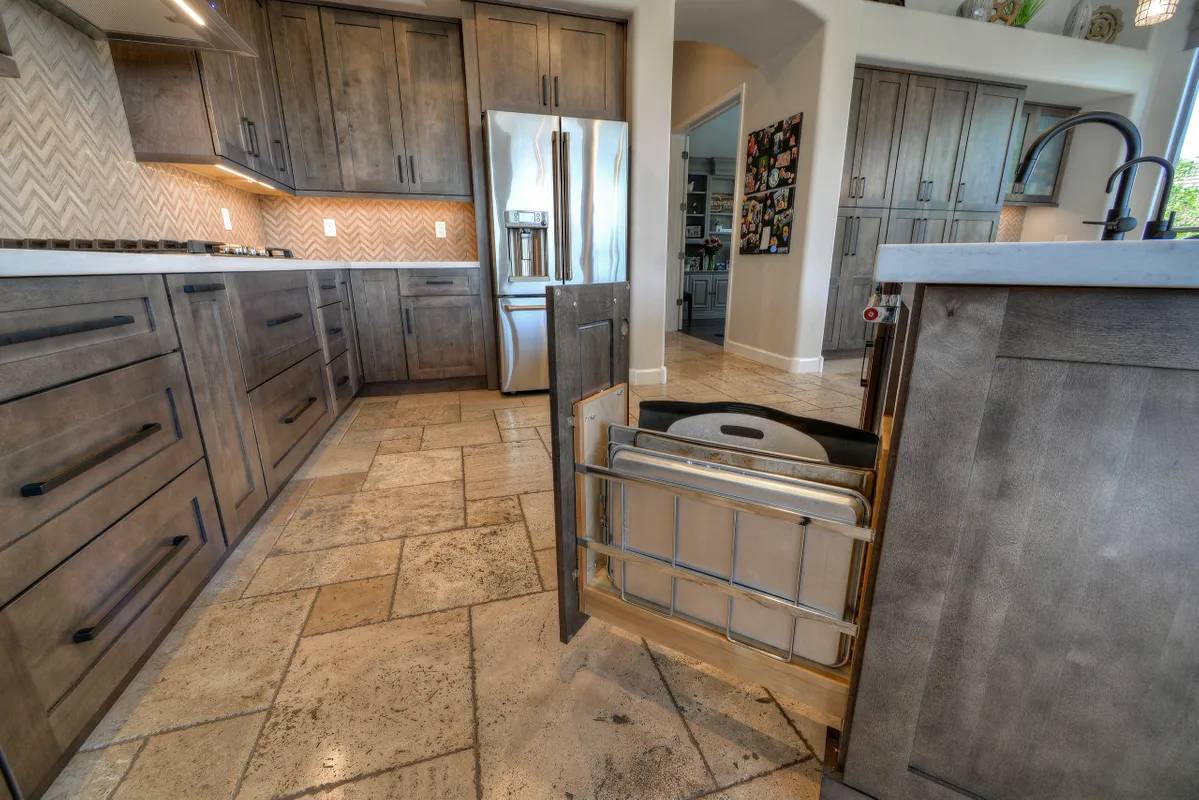 A kitchen with wooden cabinets and tiled floors