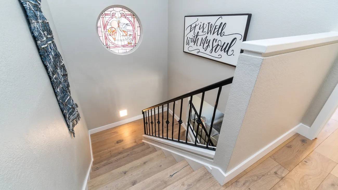 A staircase with a metal railing and wooden steps.