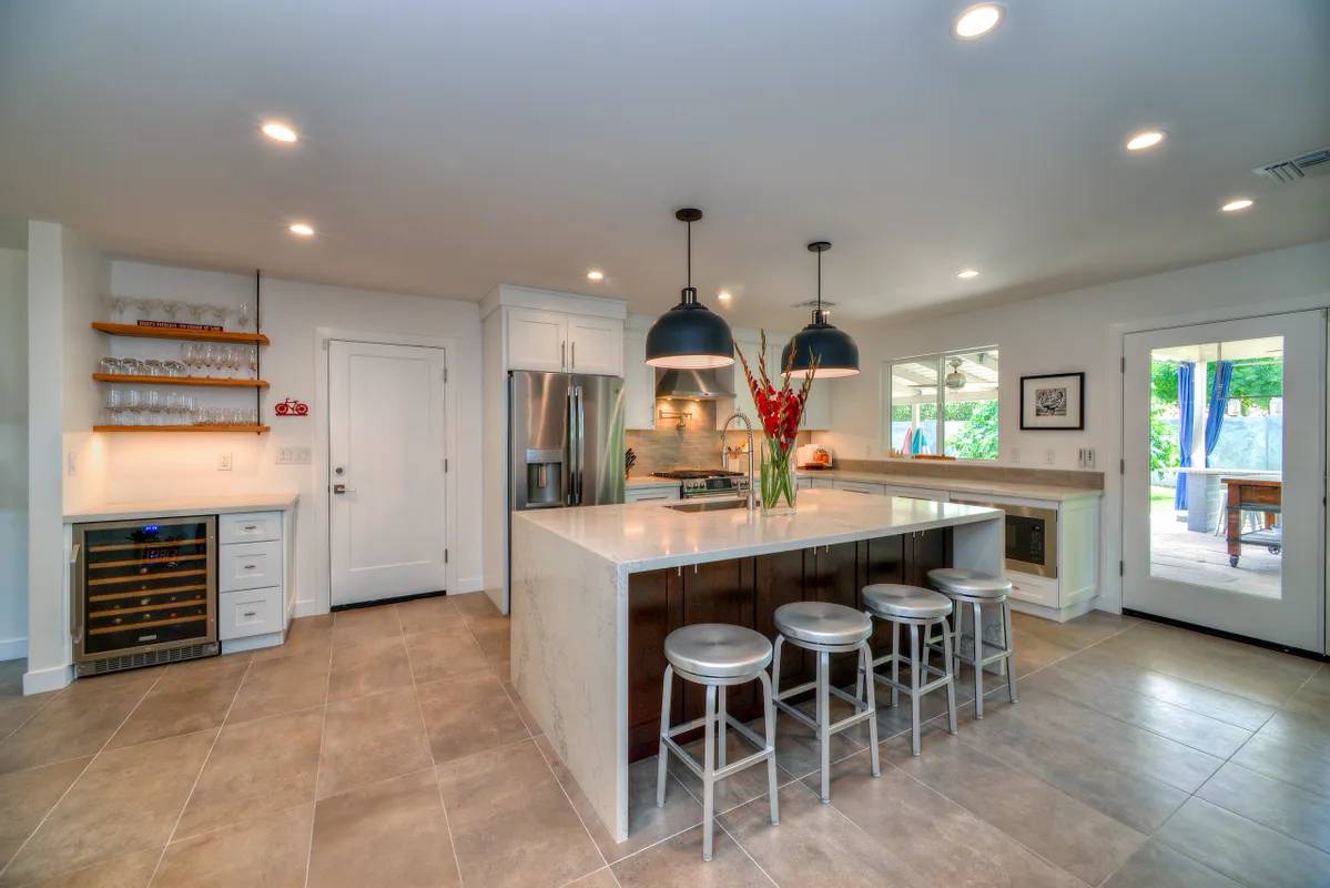 A kitchen with a large island and white cabinets.